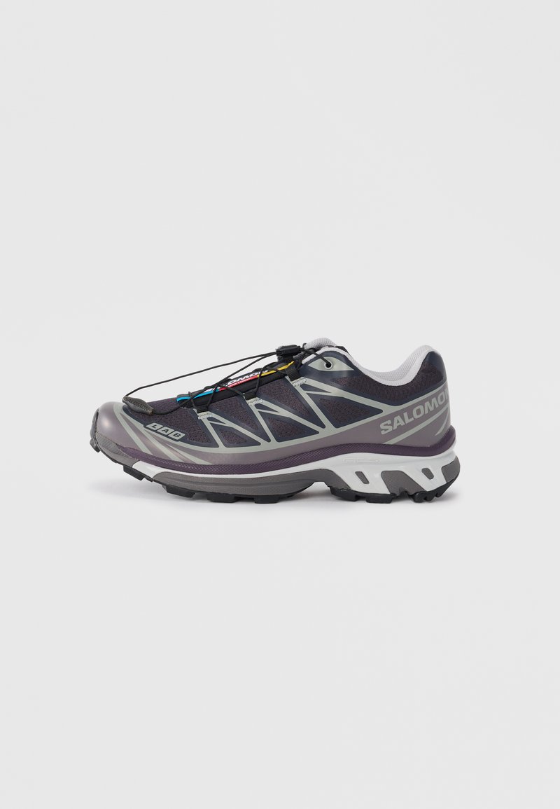 Lila Trailrunning-Schuh mit einem Obermaterial aus Mesh, reflektierenden Akzenten und einem Schnellverschlusssystem. Ausgestattet mit einer strapazierfähigen Gummisohle und einer gepolsterten Zwischensohle.