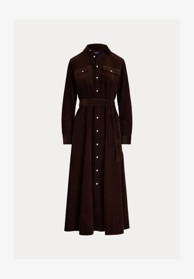 Brun kordfløjl kjole med knaplukning foran, lange ærmer, brystlommer og et matchende bælte i taljen. Trafalder længde.