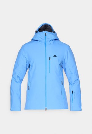 Hellblaue wasserfeste Jacke mit Kapuze, Reißverschluss vorne und zwei Seitentaschen. Mit schwarzem Logo und verstellbaren Ärmelbündchen. Glatte Textur.