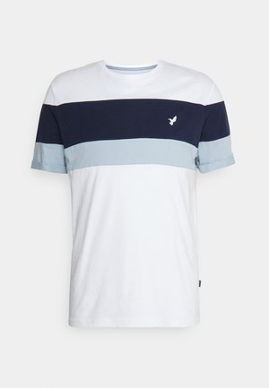 T-shirt kratkih rukava od pamuka, s prugastim blokovima boja u bijeloj, mornarskoj i svijetlop plavoj. Mali logo na prsima, zarolane rukave.