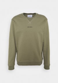 Felpa crewneck verde oliva con "LES DEUX" stampato in nero al centro del davanti, con polsini e fondo a coste e dettagli cuciti al collo.