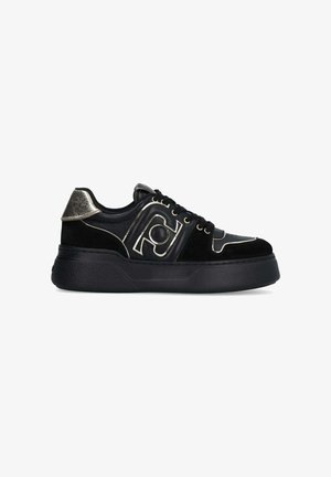 Sneaker nera con una combinazione di pelle liscia e camoscio, dettagli metallici sul tallone e sul logo, e suola in gomma testurizzata.