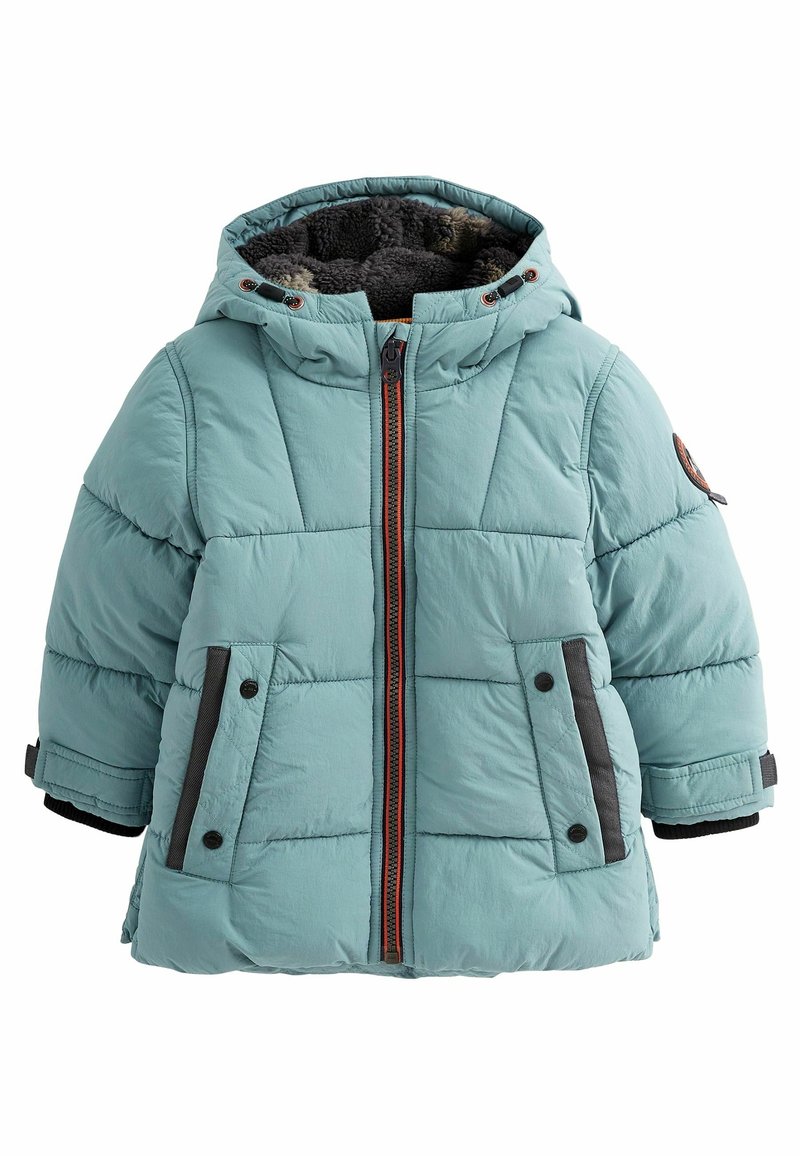 Veste d’hiver matelassée bleu clair avec capuche doublée en polaire foncée, fermeture zippée devant, deux poches à boutons-pression et sangles ajustables aux poignets.