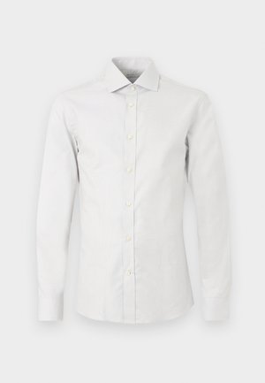 Bílá pánská košile s dlouhým rukávem, špičatým límečkem a knoflíky vpředu, zobrazena na jednobarevném bílém pozadí.