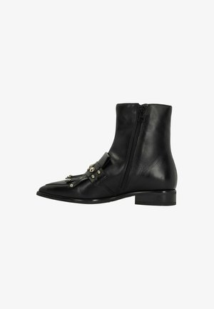Black leather ankle boot with a pointed toe, side zipper, decorative fringe, and metallic studs on the front. Low heel design.