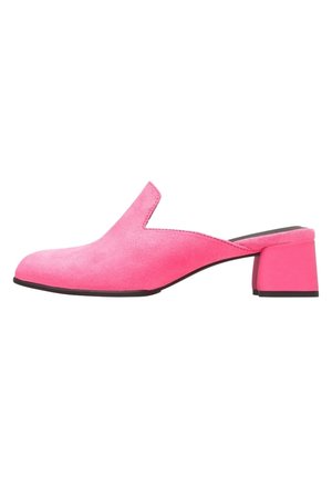 Różowe zamszowe klapki z wycięciem w kształcie litery V i niskim, kwadratowym obcasem. Gładka faktura z kontrastującą czarną podeszwą.