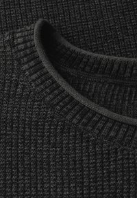 Gros plan sur un pull noir en tricot, présentant un design texturé avec un col côtelé. Le matériau semble doux et chaud, mettant en avant un look monochrome sombre.