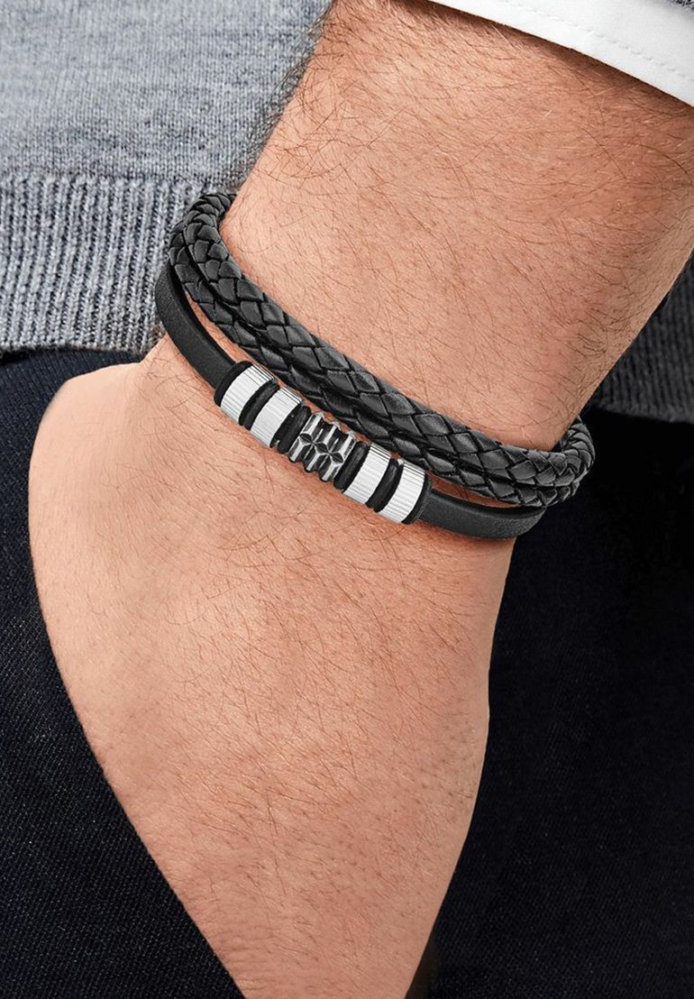 Bracciale in pelle con fili neri intrecciati e dettagli in argento. Presenta un centro testurizzato e un design elegante e moderno.