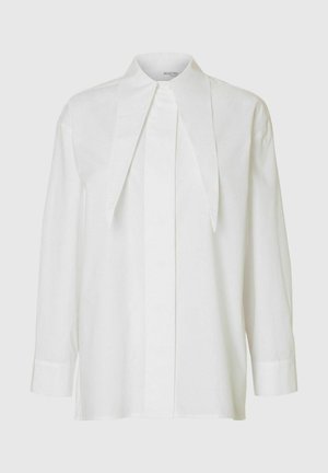 Weiße Langarmbluse mit übertriebenem spitzen Kragen und verdeckter Knopfleiste, vor einem hellen Hintergrund präsentiert.