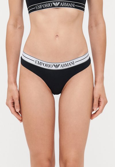 Black bikini bottoms with an elastic waistband featuring white "Emporio Armani" branding. Soft fabric with a smooth texture.