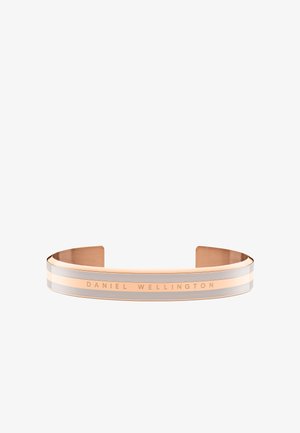 Rose gold színű karkötő, amely elegáns dizájnnal rendelkezik, fémes felületekkel és egy „DANIEL WELLINGTON” logóval, amely a külső oldalán található.