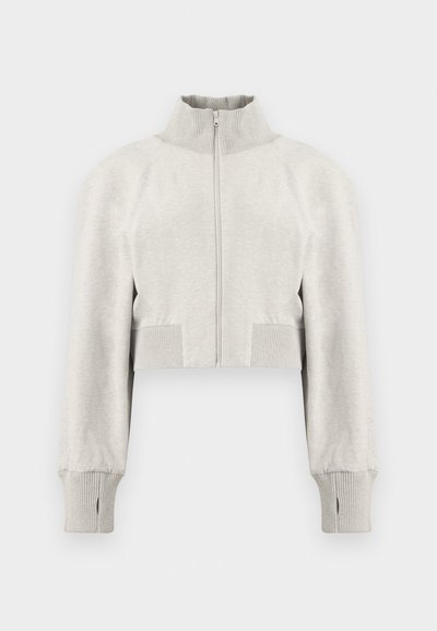 Pull court gris clair zippé avec col montant côtelé et manches longues dotées de poignets côtelés avec trous pour les pouces.