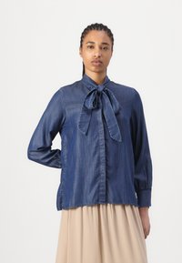 Dunkelblaues Jeanshemd mit einer Schleife am Hals, langen Ärmeln und geradem Schnitt. Verfügt über eine Knopfverschluss und eine weiche Textur.