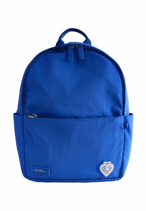 Zaino blu Cath Kidston con tasca frontale, doppia cerniera, portabottiglie laterale e emblema di pizzo a forma di cuore bianco nell'angolo in basso a destra.