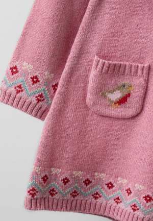 Rozā adīta auduma gabals ar mazu kabatu, kurā ir putna motifs, un dekoratīvi sarkanie, balti un zili raksti pa malām.