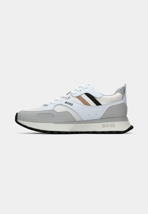 Running shoes featuring a white mesh upper with grey suede accents, black and beige stripes, and a black rubber outsole. Brand logo displayed.
