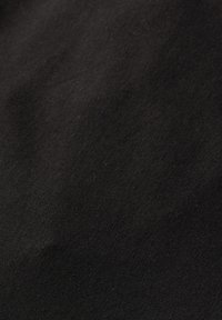 Tessuto nero con una superficie morbida e testurizzata. I dettagli mostrano un colore uniforme con lievi variazioni, che indicano una composizione in fibra naturale.