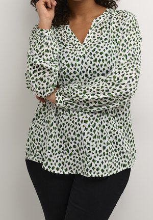 Biała bluzka z długim rękawem w zielono-niebieski zwierzęcy wzór, z dekoltem w serek i luźnym krojem. Tkanina o fakturze.