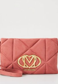 Mala de mão rosa acolchoada com logótipo dourado da Love Moschino e alça para o pulso, sobre fundo branco.