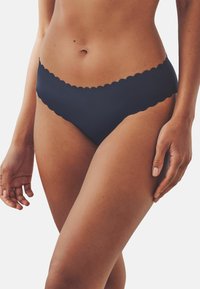 Donkerblauwe bikinibroek van gladde stof, met een scalloped randontwerp. Elastische tailleband en een minimalistische pasvorm.