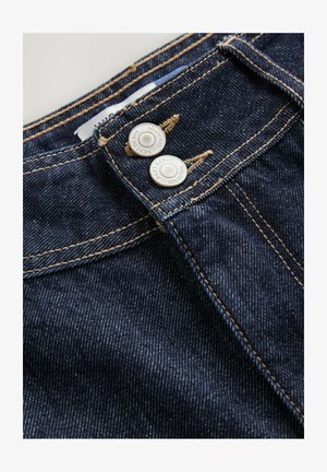 Dark blue denim jeans feature a close-up view of the waistband with two metal buttons, contrasting golden stitching, and a textured fabric surface.