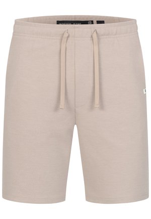 Pantalones cortos casual beige con cintura ajustable con cordón y textura sutil, con pequeña etiqueta de marca lateral y cintura elástica.