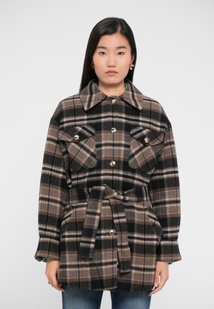 Veste à carreaux marron, noir et beige avec un col, deux poches poitrine, des boutons dorés et une ceinture à nouer. Texture en flanelle, coupe décontractée.