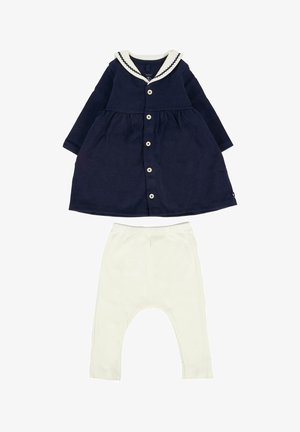 Navyblauwe babyjurk met witte zeeman kraag en knopen, gecombineerd met witte babylegging met elastische taille.