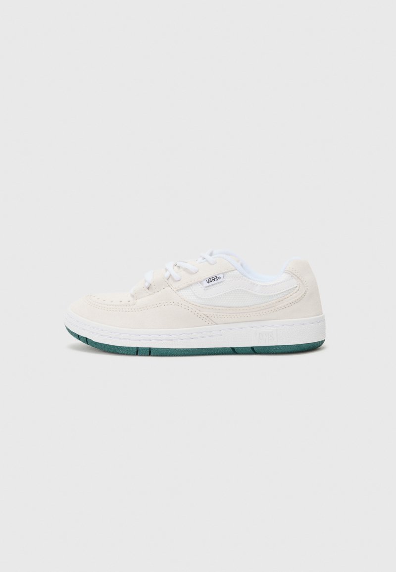 Beige nubukist sneakers valgete aktsentidega, ümmarguse kujuga ja rohelise kummitaldaga. Omab paelu ja külge logodetaili.