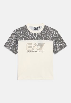 Majica kratkih rukava kremaste boje siva uzorka na ramenima i rukavima, s logotipom EA7 Emporio Armani u sredini prsa.