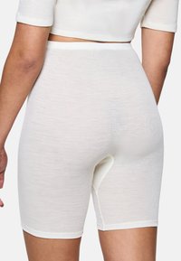 Witte naadloze shorts met een soepele, ribbelige textuur. Heeft een middellange taille en een open kruis voor gemak.