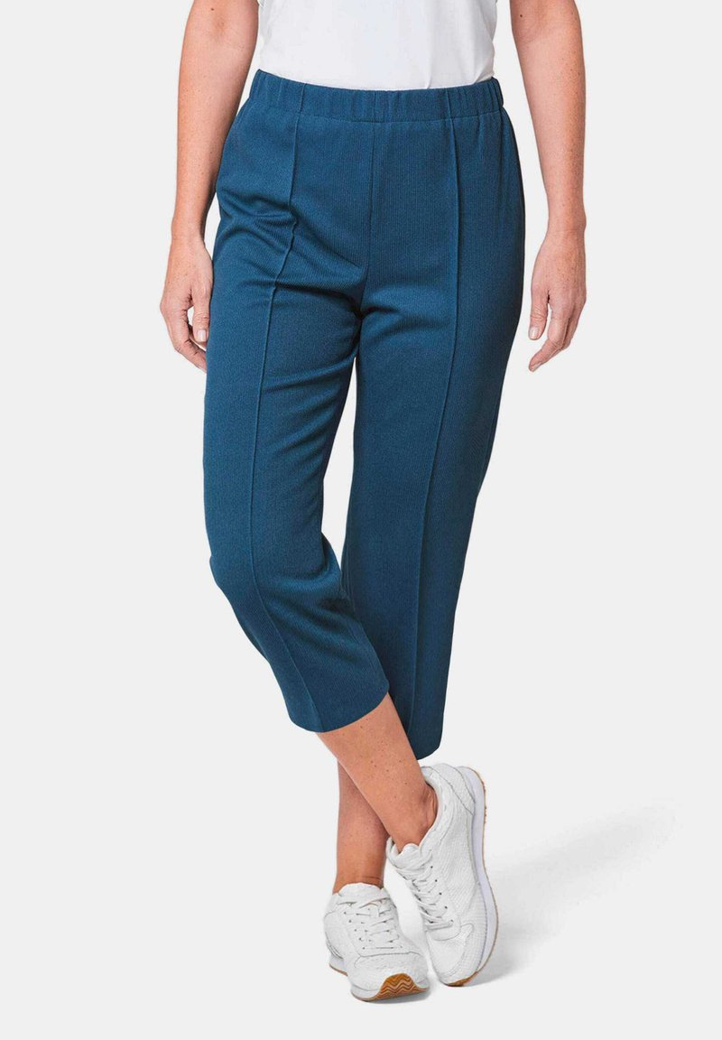 Teal cropped broeken met een textuurstof, een elastische tailleband en twee voorkreukels, gecombineerd met witte sneakers.