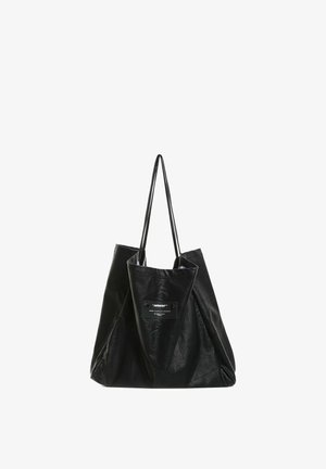 Bolso tote de cuero negro con asas largas y delgadas y una etiqueta rectangular cosida en el centro delantero.