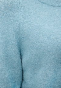 Απαλό, ανοιχτό μπλε μάλλινο ύφασμα πουκάμισου με λεπτή πλέξη και ελαφριά θολούρα, με ορατή κάθετη ραφή.