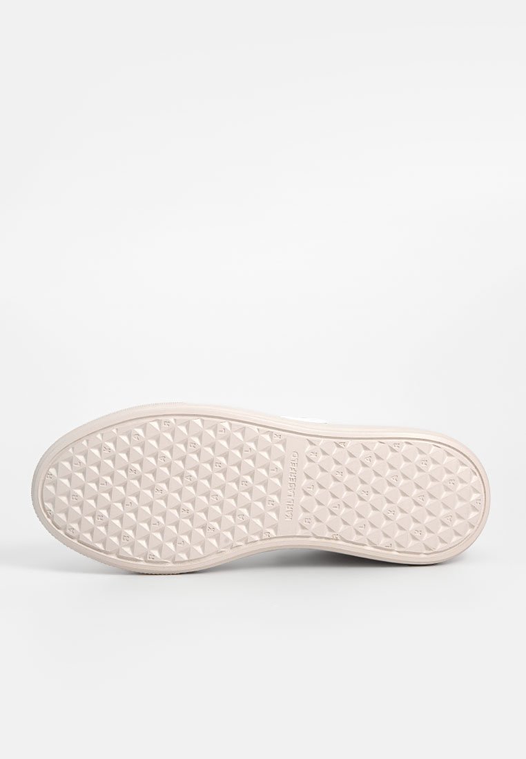 Suela de una zapatilla de color claro con un patrón de agarre triangular texturizado y el nombre de la marca "CATERPILLAR" grabado en el centro.