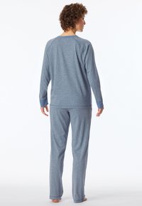 Conjunto de salón gris hecho de tela suave. Presenta mangas largas con puños de canalé y pantalones a juego. Diseño simple, ajuste relajado.
