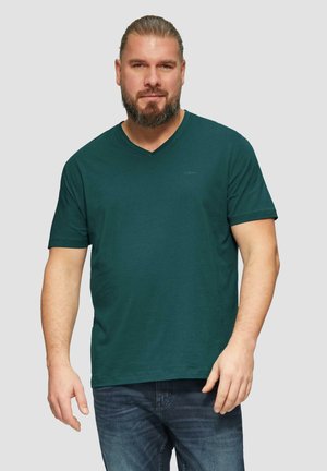 Groene katoenen V-hals T-shirt met korte mouwen, met een eenvoudige uitstraling en een klein logo op de bovenste linkerkant. Gemaakt met blauwe spijkerbroeken.