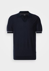 Polo à manches courtes bleu marine en tissu tricoté. Il présente un col en V, un col contrastant et des accents blancs sur les manches et l'ourlet inférieur.