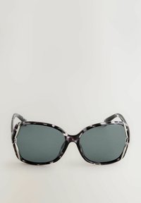 Occhiali da sole con lenti grigie scure, montatura in plastica marmorizzata in bianco e nero, design angolare e riflessi argentati lucidi sulle tempie.
