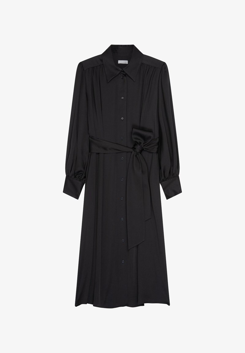 Longue robe noire boutonnée avec manches longues, large col, tissu froncé aux épaules et poignets, et ceinture nouée à la taille.