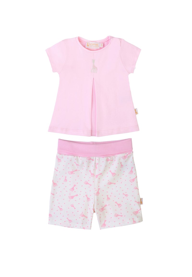 Top a maniche corte rosa chiaro con dettaglio di giraffa ricamato e una plissettatura. Pantaloni corti bianchi abbinati con motivo di giraffe rosa e pois.