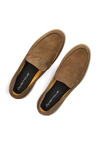 Braune Wildleder-Slipper mit abgerundetem Zehenbereich und kontrastierendem gelben Futter. Schwarze Innensohle mit dem Markennamen "Ambitious."