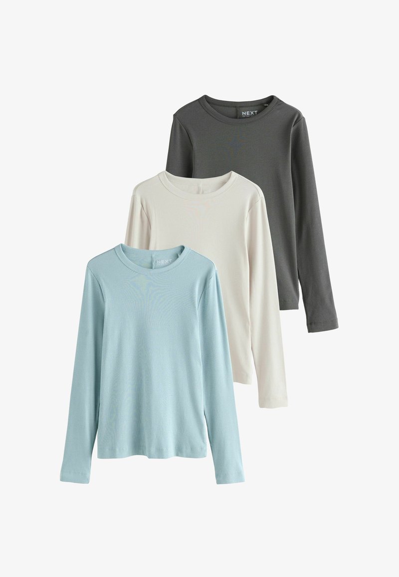 Three long-sleeve t-shirts in light blue, off-white, and dark gray. Ribbed texture and round necklines. Brand label visible on dark shirt.