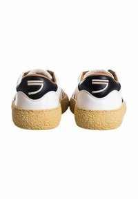 Sneakers bianchi in pelle con una suola texturizzata color tan, dotati di un accento sul tallone nero e di un semplice design stampato sul retro.