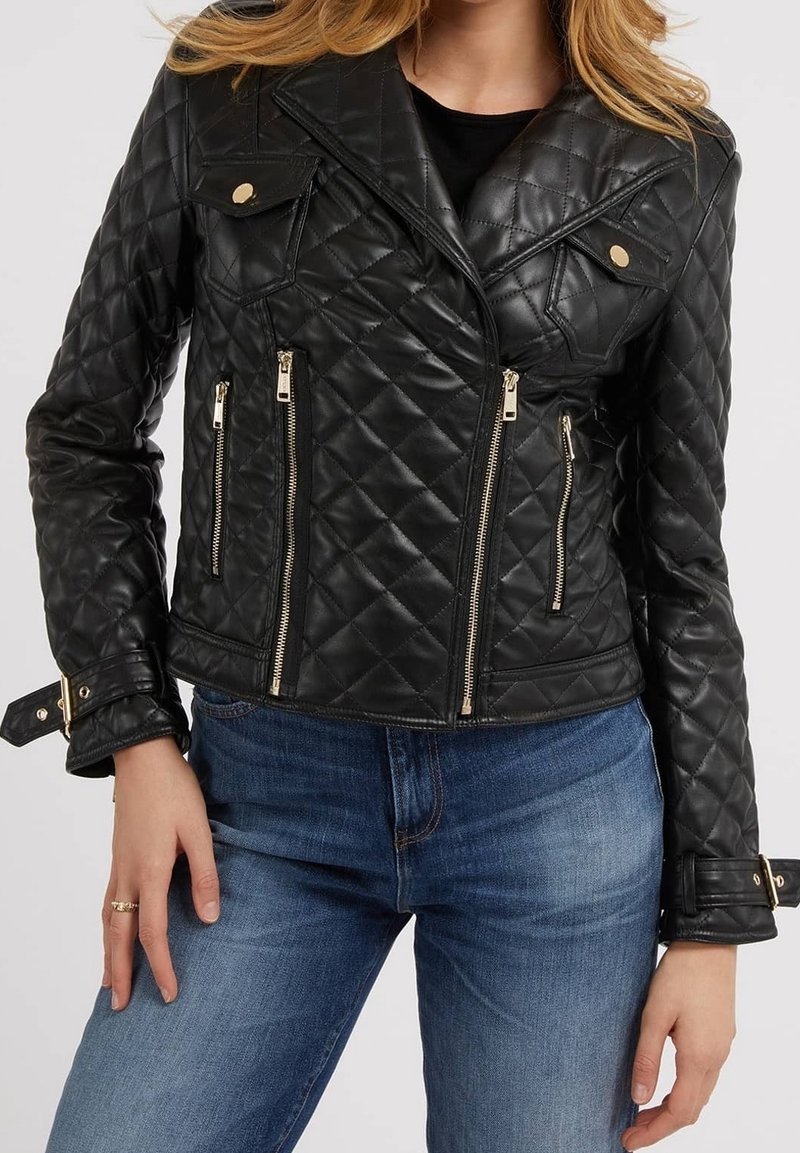 Veste en cuir noire matelassée avec fermeture éclair sur le devant et poches, featuring des accents en métal doré et un design ajusté.