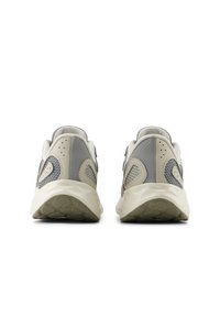 Gray and beige athletic shoes with a textured mesh upper, cushioned sole, and distinct curved heel design. No visible branding.