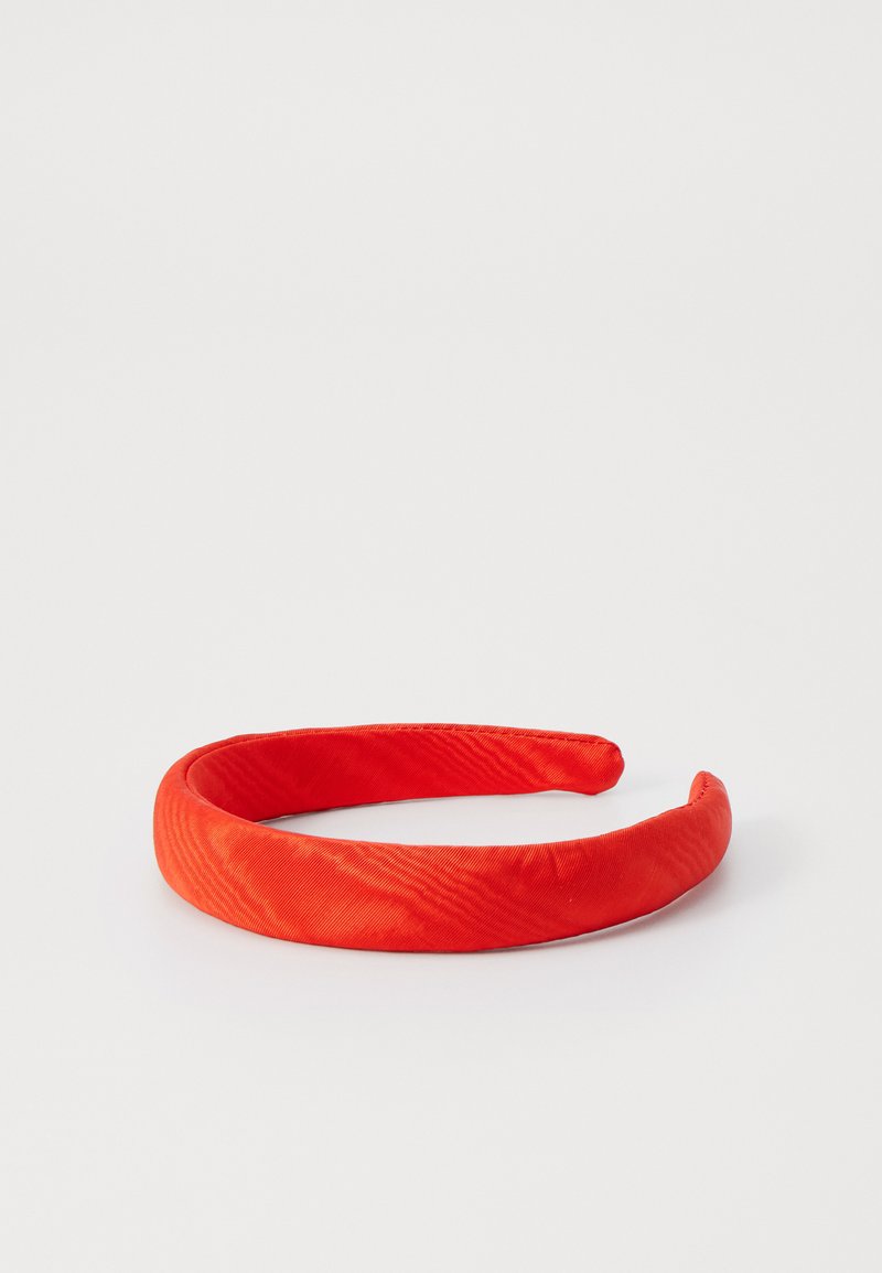 Red fabric headband with a smooth texture, rounded shape, and a solid color. No visible hardware or additional embellishments.