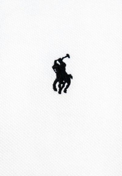 Must tikitud logo, kus on polo mängija hobusel, kes hoiab malletit, valgel tekstuuriga kangal.