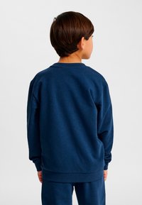 Mörkblå sweatshirt med rund halsringning, ribbade muddar och fåll. Tillverkad av mjukt tyg med en slät yta, designad för vardagsbruk.