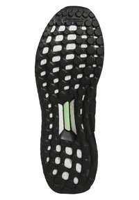 Semelle de chaussure en caoutchouc noir avec une surface texturée présentant des motifs circulaires, des accents blancs et un détail vert du système Torsion.